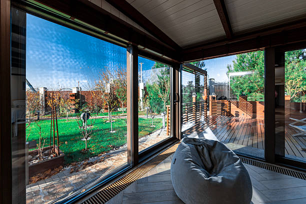 A large room with a view of a yard. A white bean bag chair is in the middle of the room