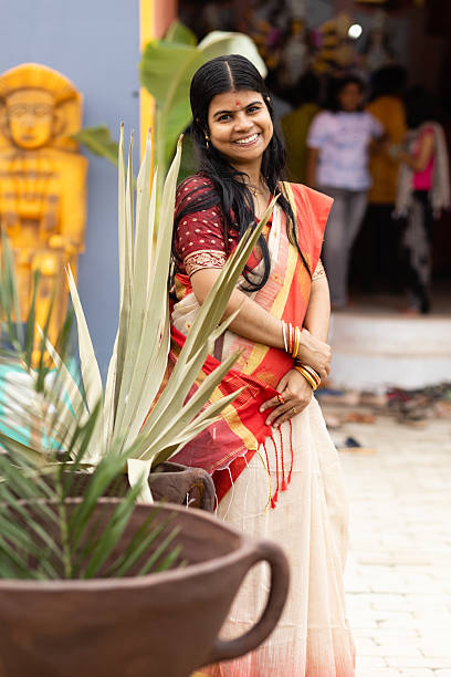 An Indian ethnicity beautiful female in red sari standing and smiling during durga puja festival