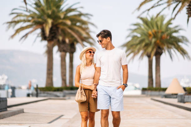Couple walking by tropical port in Tivat, Montenegro
