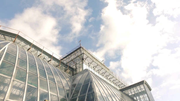 istock Low angle view of large modern greenhouse with blue clouded sky 2203630379
