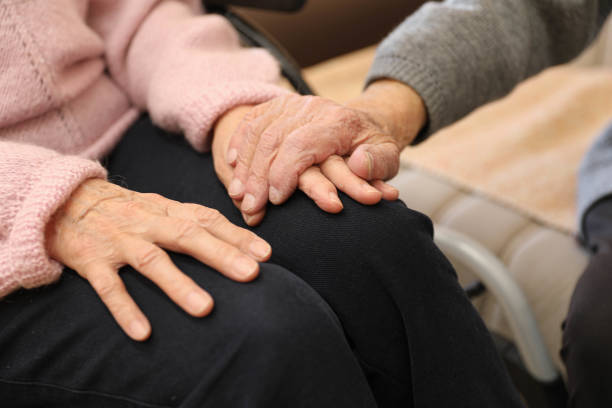 istock Caregiver gently holding an elderly woman's hands. 2203636604