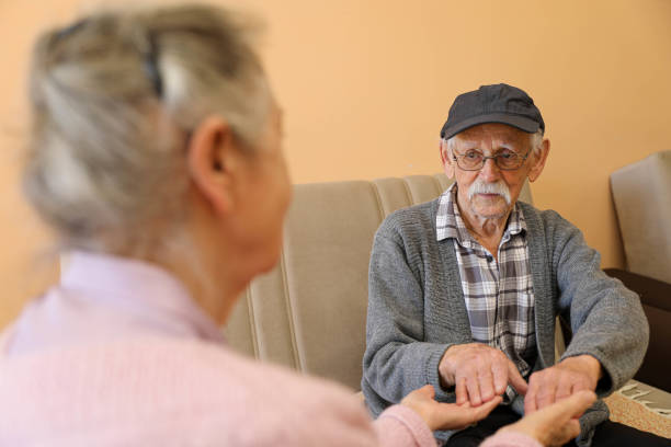 Compassionate Care: A Caregiver Holding an Elderly Woman’s Hands
