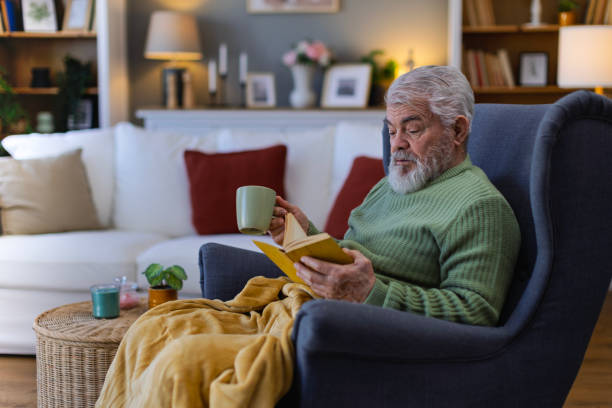 istock Pensioner in daily activities at home, reading a book 2203637340