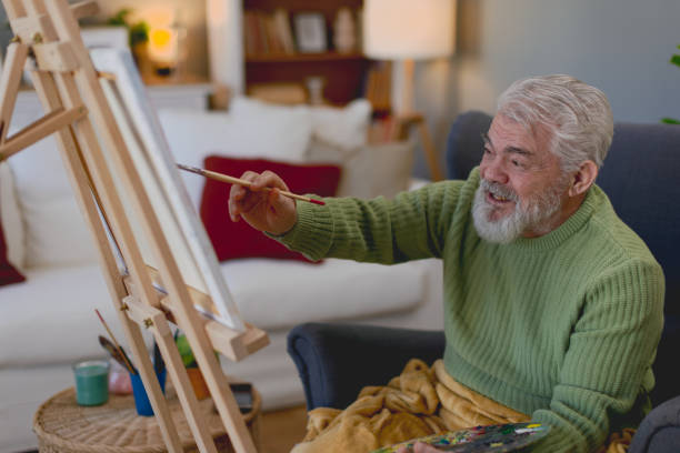 istock Pensioner in daily activities at home, drawing on canvas 2203637428