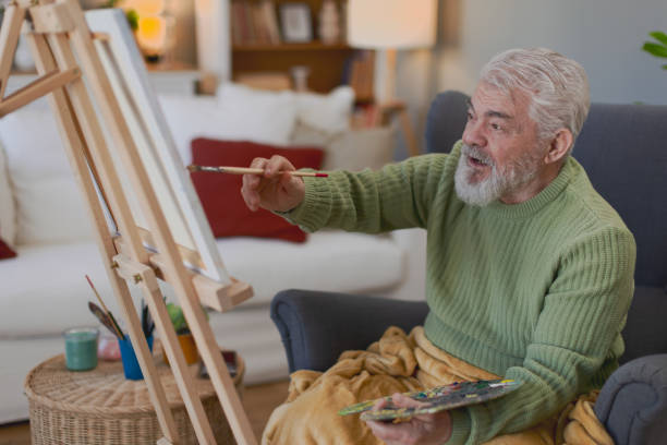istock Pensioner in daily activities at home, drawing on canvas 2203637443