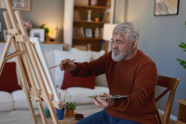 istock Pensioner in daily activities at home, drawing on canvas 2203637496
