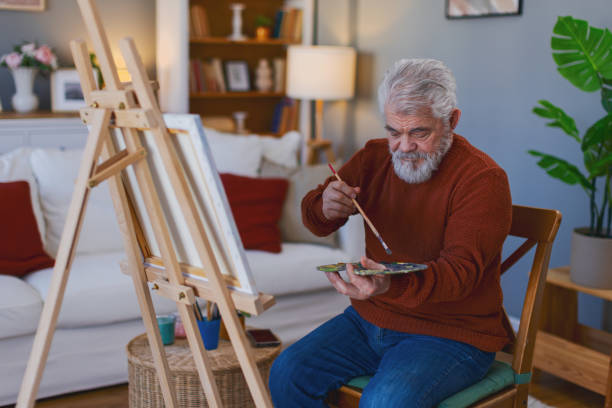 istock Pensioner in daily activities at home, drawing on canvas 2203637500
