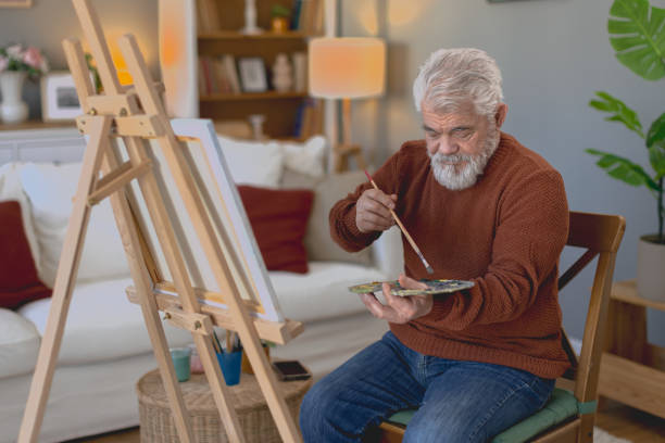 istock Pensioner in daily activities at home, drawing on canvas 2203637501