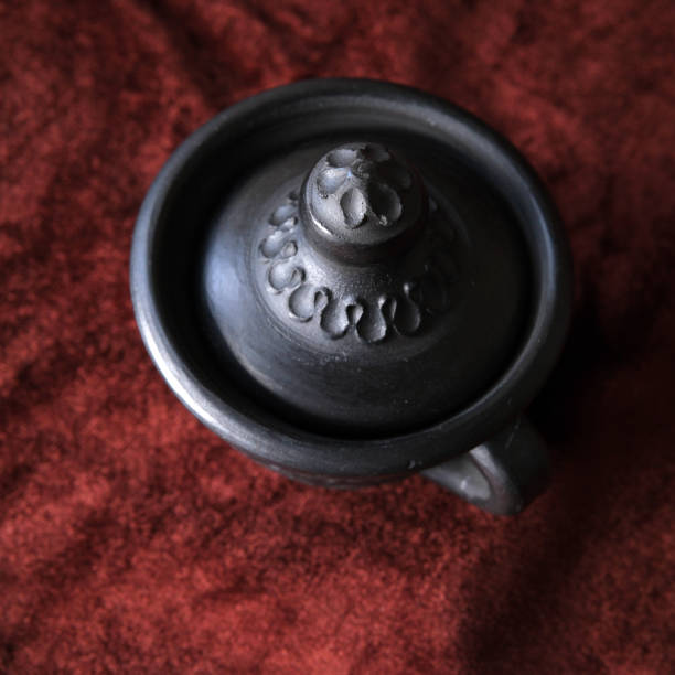 Handcrafted pottery showcases detailed designs against rich fabric.