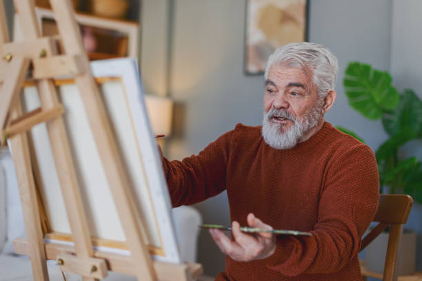 istock Pensioner in daily activities at home, drawing on canvas 2203637606