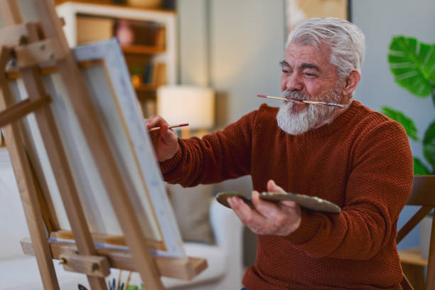 istock Pensioner in daily activities at home, drawing on canvas 2203637667