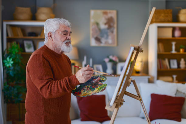 istock Pensioner in daily activities at home, drawing on canvas 2203637679
