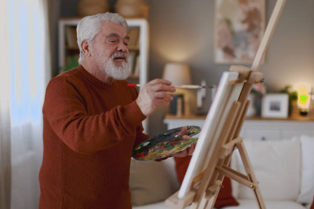 istock Pensioner in daily activities at home, drawing on canvas 2203637734