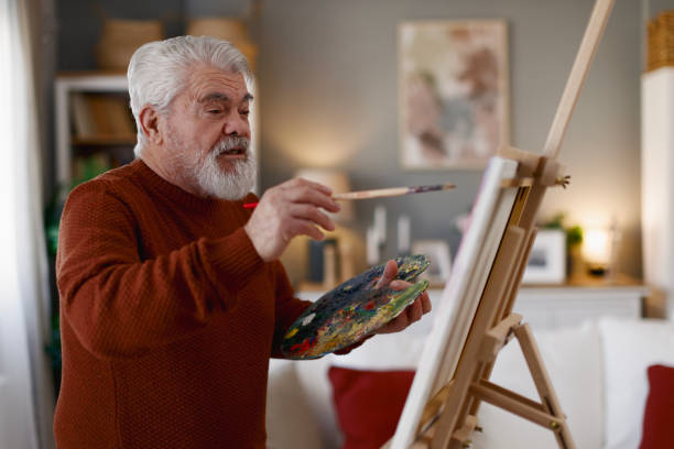 istock Pensioner in daily activities at home, drawing on canvas 2203637783