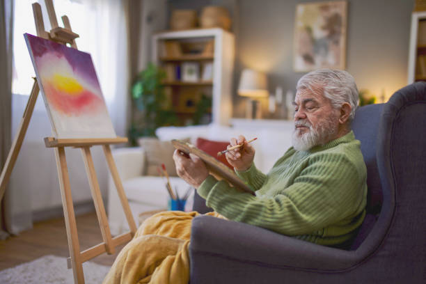 istock Pensioner in daily activities at home, drawing on canvas 2203637894