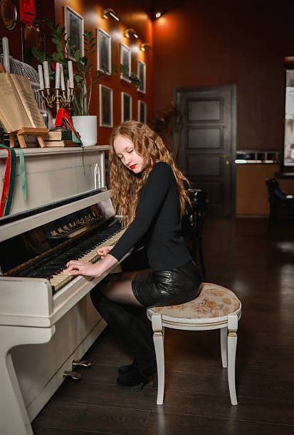 istock A beautiful girl plays the piano. 2203638138