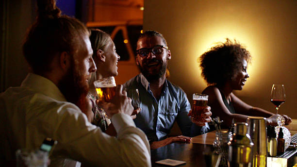 istock Happy multiethnic friends enjoying drinks during night at bar. 2203638782
