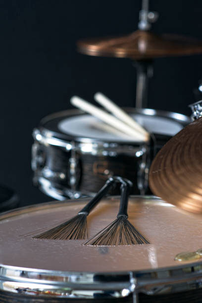 istock Pair of jazz drum brushes lying on a floor tom during music session 2203643143