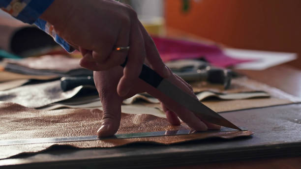 istock Skinner is marking and taking metal ruler and knife for cutting 2203643328