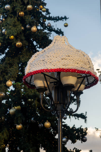 istock Unique lamp post decoration with knitted design near Christmas tree 2203646595