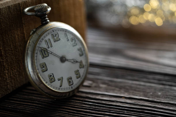 vintage silver pocket watch on wood background