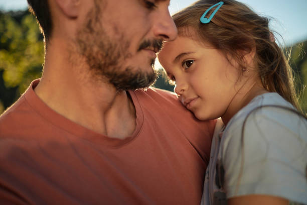 Young father consoling his daughter stock photo