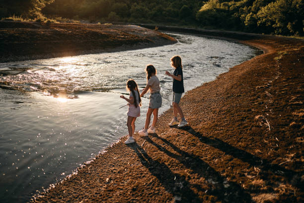 Siblings are playing on a river. It’s a beautiful sunset.