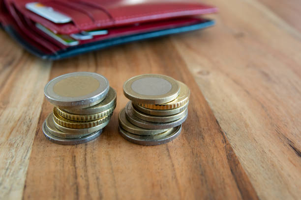Coins stack on the wood table near the leather partmone. Wallet with european money for commerce business concept.