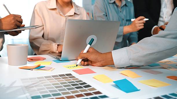 istock Collaborative Creative Brainstorming Session with Colorful Sticky Notes and Laptops in a Modern Office Environment SACTR 2203648748