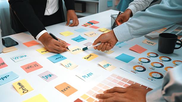 istock Collaborative Team Brainstorming Session with Sticky Notes and Charts on White Table in Modern Office Environment SACTR 2203648826