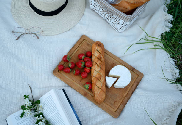 istock Cozy picnic setup with fresh baguette, cheese, and strawberries 2203652803