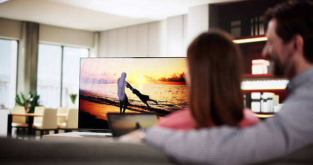 Man watching internet streaming from connected tablet to television