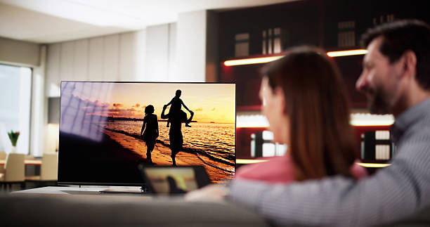 istock Man streaming video from tablet to television 2203658265