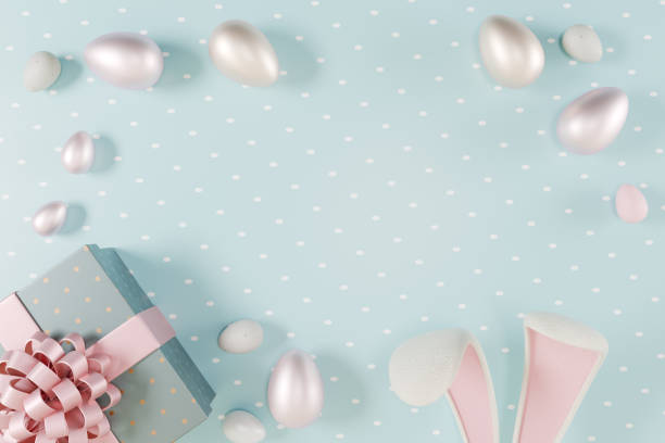 istock Easter scene with pastel eggs, a gift box, and bunny ears on a blue polka dot background. 3d rendering 2203660528