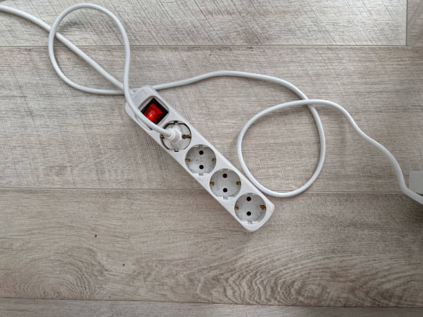 istock An extension cord with multiple outlets lying on a wooden floor. Practicality and utility in modern home setups. Electric power concept 2203660631