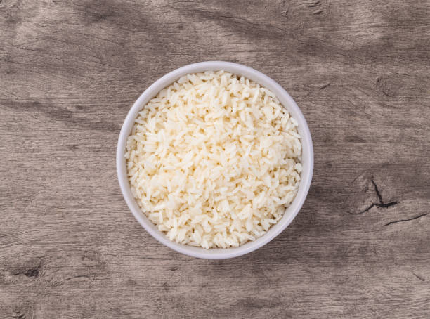istock Cooked white rice in a bowl over wooden table 2203662634