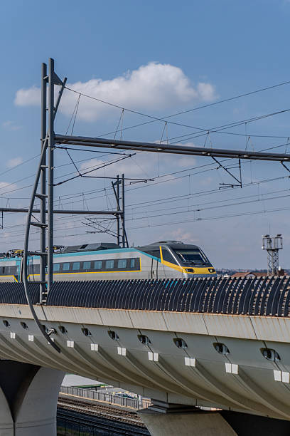 istock Fast train traveling on railway bridge under blue sky with clouds 2203667494
