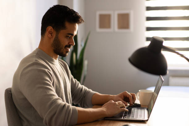 istock Young businessman working from home typing on his laptop computer 2203667916