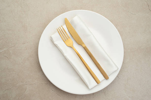 istock White plate with gold cutlery on the table 2203675439