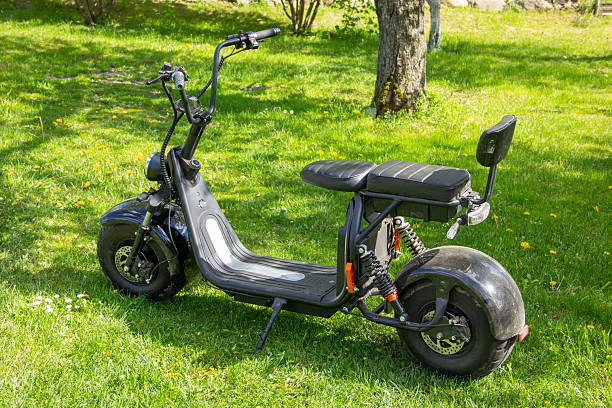 istock small black electric scooter standing still on green sunny lawn 2203675793