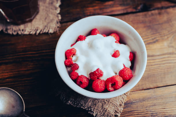 Summer Dessert with Fresh Raspberries and Greek Yogurt in Bowl on Wooden Table