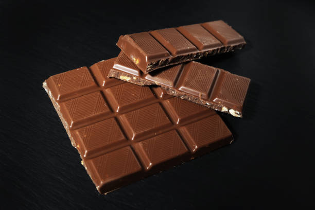 chocolate bar on black background. milk chocolate on black stone. in the center of the frame