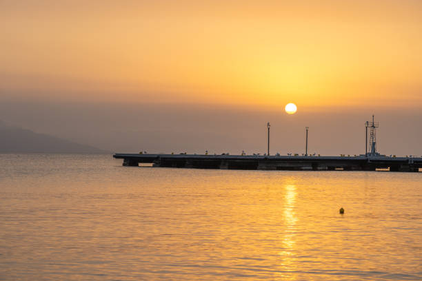 istock Sunsets over bay delivering a golden glow over calm water 2203677678