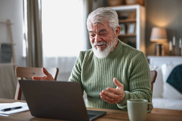 istock A pensioner sits at the dining room table and works on a laptop 2203686425