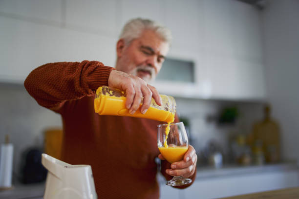 istock Old retired man making fruit and vegetable shake at home 2203691916