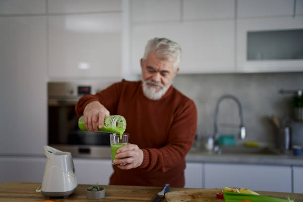istock Old retired man making fruit and vegetable shake at home 2203692018