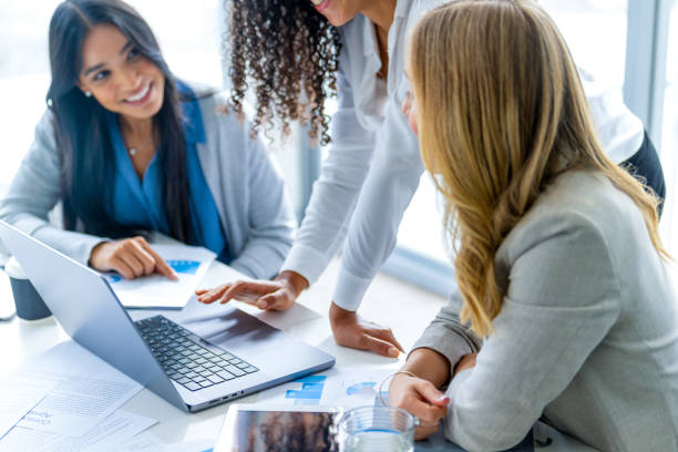 istock Happy group of business women working on a laptop computer. 2203692127