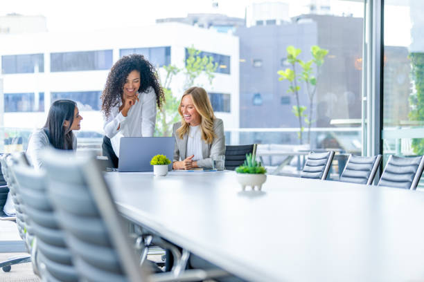 istock Three business  women meeting. They are discussing something while looking at a laptop computer. 2203692352