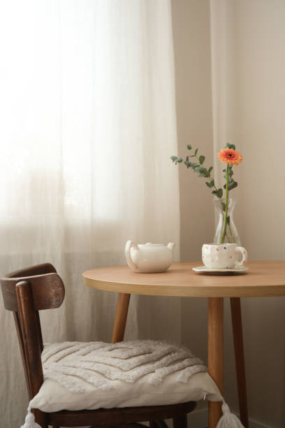 istock A stylish dining table with a charming floral arrangement and an inviting teapot on top 2203696418