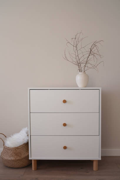 istock This stylish and highly functional white dresser with ceramic vase with elegant dry branches, straw basket. 2203700819